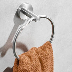 Brushed silver stainless steel towel ring mounted on wall holding orange towel.