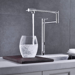 Brushed nickel two-handle brass kitchen pot filler faucet filling a glass with water.