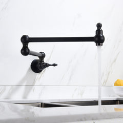 Matte black brass wall mount folding pot filler faucet with extendable arm over sink.