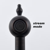 Matte black brass wall-mount pot filler faucet in stream mode with ornate handle.