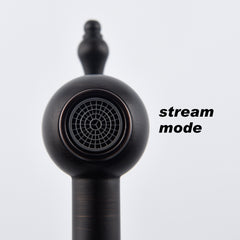 Matte black brass wall-mount pot filler faucet in stream mode with ornate handle.