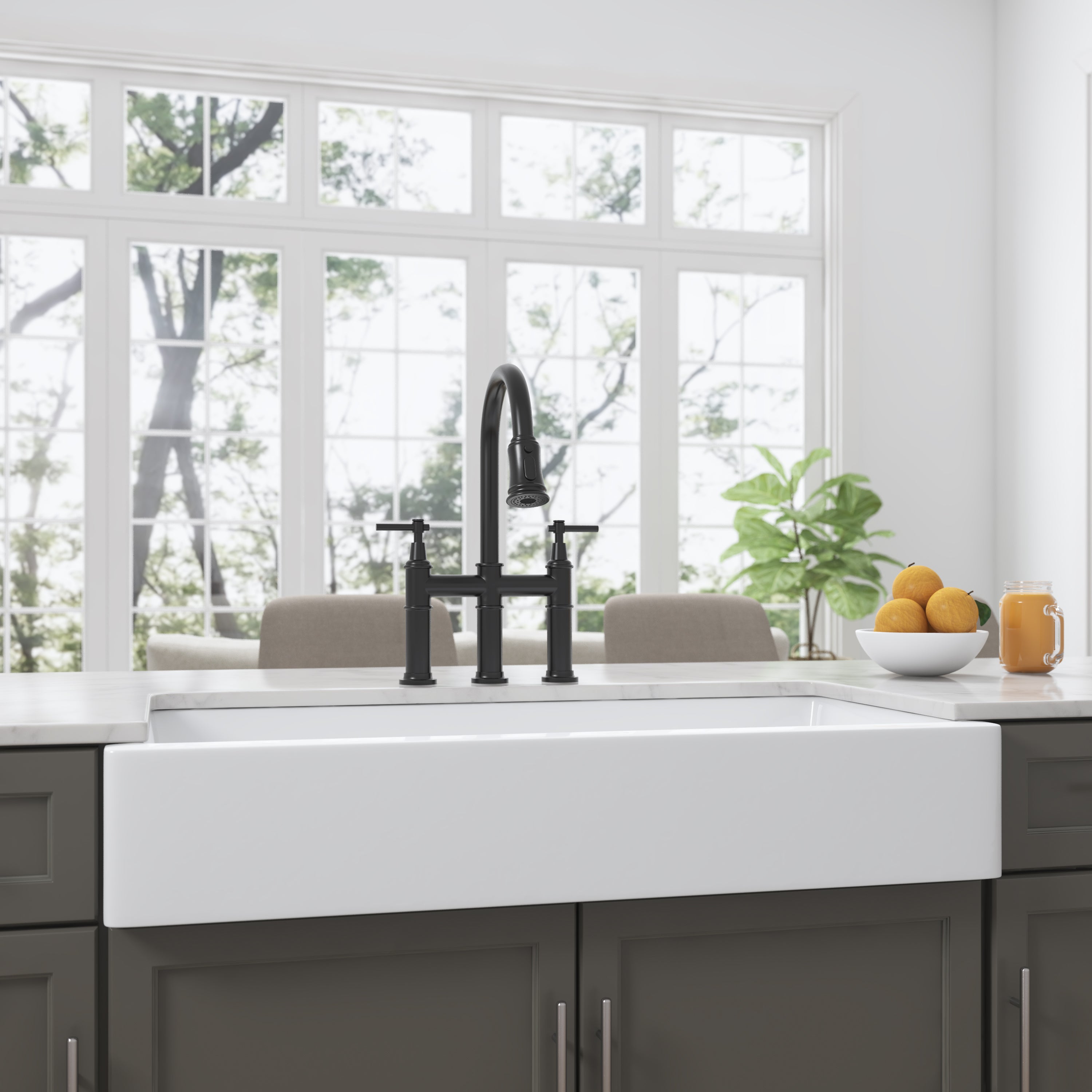 White ceramic 36-inch apron-front farmhouse sink with black bridge faucet in a bright kitchen.