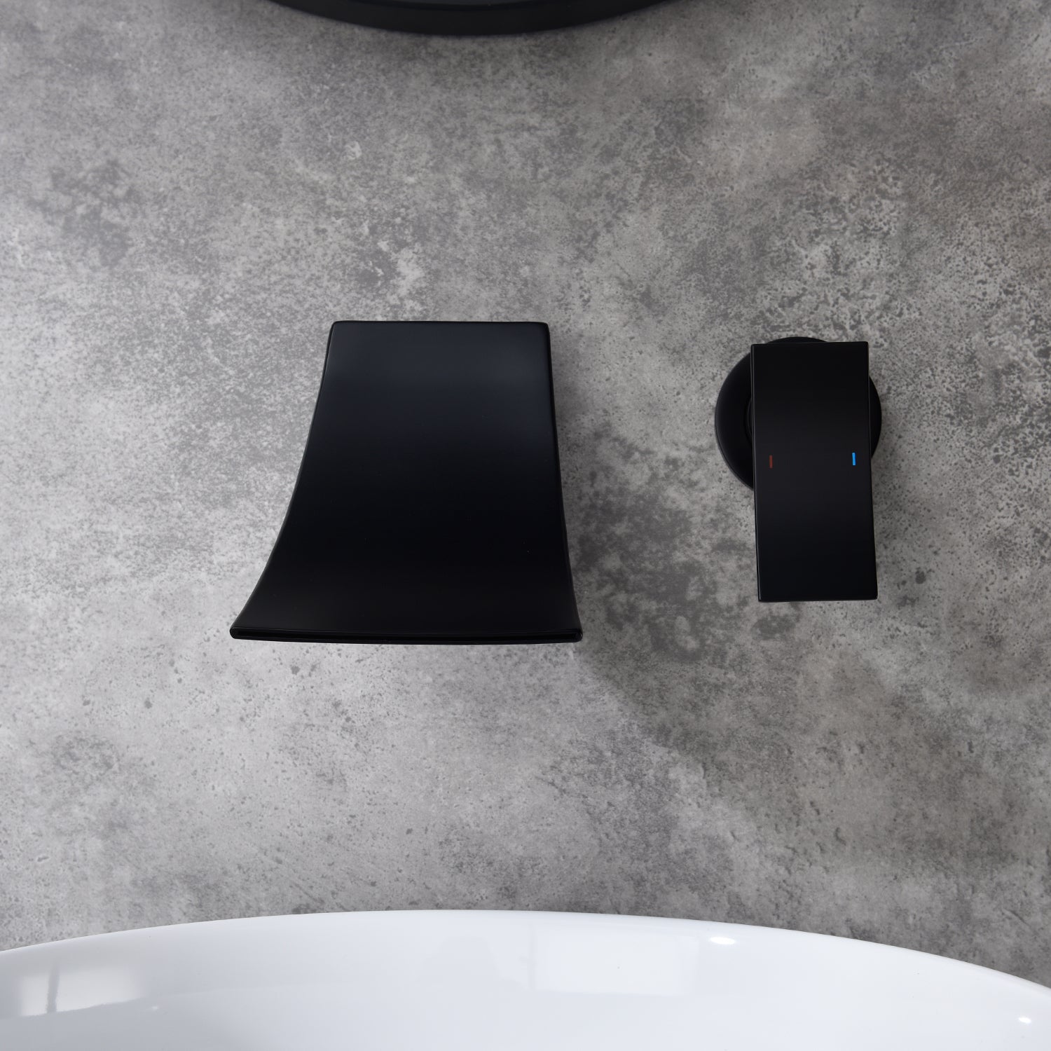 Matte black wall-mount bathroom waterfall faucet with single handle on gray surface.