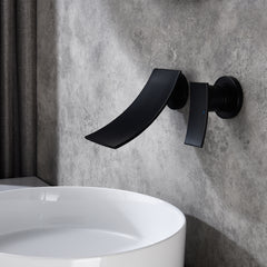 Matte black wall-mount bathroom waterfall faucet with single handle over white sink.