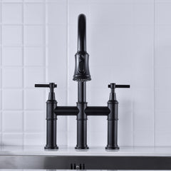 Matte black pull-down double-handle kitchen faucet with bridge design on white tiles.