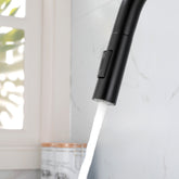 Black stainless steel single-handle high-arc pull-down kitchen faucet spraying water.