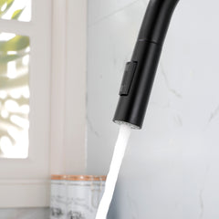 Black stainless steel single-handle high-arc pull-down kitchen faucet spraying water.