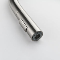 Close-up of stainless steel pull-down kitchen faucet with high arc and sprayer head.