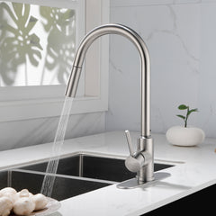 Stainless steel high arc pull-down kitchen faucet with single handle and sprayer over sink.