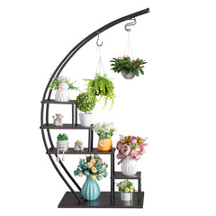 A black iron semicircle plant stand with five tiers displaying various potted plants and flowers.