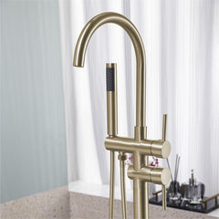 Brushed gold freestanding floor-mount bathtub faucet with handheld sprayer.