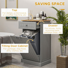 Gray kitchen cabinet with tilting trash bin door, drawer, and wood top.