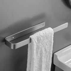 Wall-mounted gun grey aluminum towel ring holding a white towel in a bathroom.