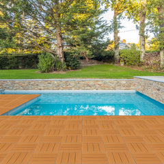 Light brown interlocking plastic deck tiles forming a patio around a pool.
