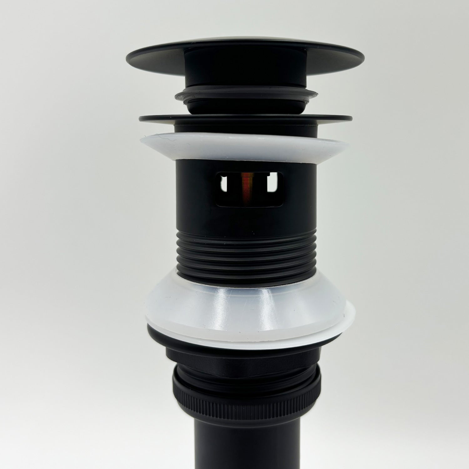 Black bathroom sink pop-up drain with overflow, featuring white silicone gaskets.
