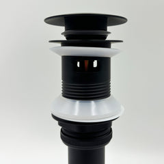Black bathroom sink pop-up drain with overflow, featuring white silicone gaskets.