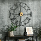 A 36-inch rustic wall clock with black metal frame, wood accents, and Roman numerals on a gray textured wall.
