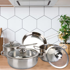 Stainless steel cookware set with two stockpots, saucepan, and frying pan on wooden surface.