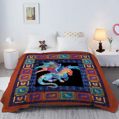 A flannel throw blanket with a colorful dragon print on a bed.