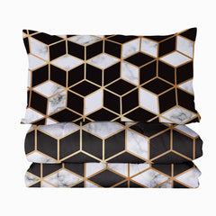 Queen-size reversible comforter set with black, white, and gold geometric cube pattern, including two shams.
