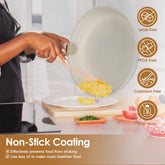 A woman uses a gray nonstick frying pan to flip scrambled eggs, highlighting its lead-free and PFOA-free coating.