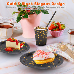 Black and gold disposable dinnerware set with plates, cups, utensils, and strawberries on a table.