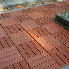 Dark brown interlocking deck tiles laid in a basketweave pattern next to a stone border.