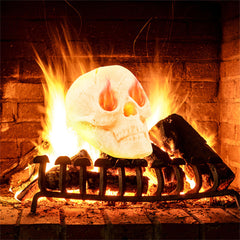 A beige ceramic skull with fiery eyes sits in a burning fireplace.