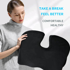 A woman in a gray turtleneck holds a black U-shaped ergonomic seat cushion.