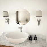 A 15.7-inch round glass wall mirror mounted above a white sink in a modern bathroom.