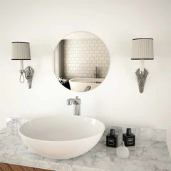 A 15.7-inch round glass wall mirror mounted above a white sink in a modern bathroom.