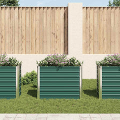 Three green galvanized steel raised garden beds with purple flowers, set against a wooden fence.