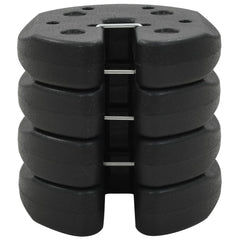 Four black plastic gazebo weight plates with concrete fill, stacked and interlocked.