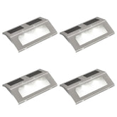 Four stainless steel solar-powered stair lights with integrated panels and LED glow.