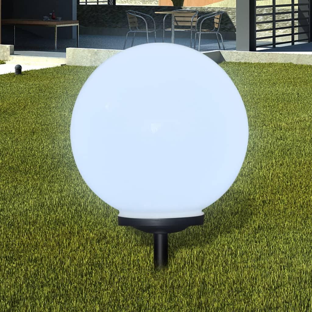 White 15.7-inch LED solar pathway lamp with glowing ball and ground spike on grass.