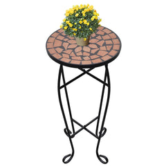 Round terracotta mosaic side table with black iron frame, topped with yellow flowering plant.