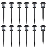 12 black plastic solar LED garden stake lights with lanterns and spikes.