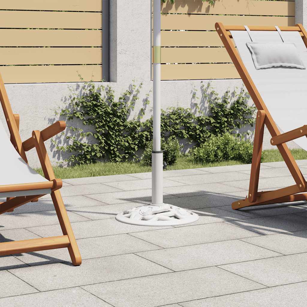 White cast iron umbrella base with ornate scrollwork on a patio.