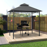 Anthracite steel BBQ gazebo with slatted sides, peaked roof, and built-in counters around a charcoal grill on a wooden deck.