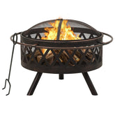 A round, rustic steel fire pit with a mesh spark screen, burning logs, and a poker.