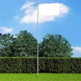 Silver 13.1-foot telescopic aluminum flagpole in a yard with blue sky and green trees.