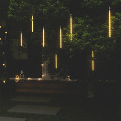 Eight warm white LED meteor rain lights hanging from a tree, creating a cascading glow.