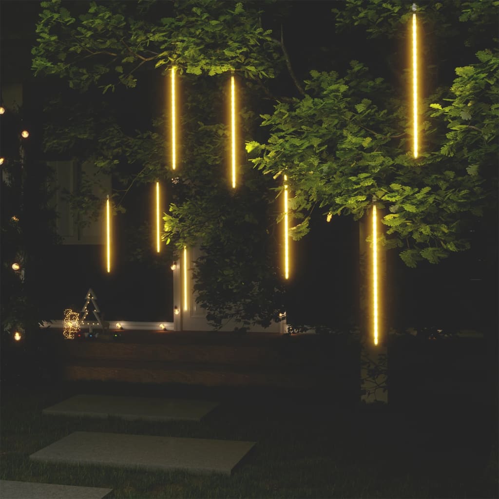Eight 2-foot warm white LED meteor rain lights hanging from tree branches at night.