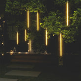 Eight 2-foot warm white LED meteor rain lights hanging from tree branches at night.
