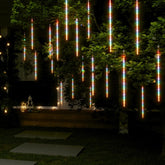 20 colorful meteor rain lights with 720 LEDs cascading from a tree at night.