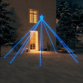 A 12ft blue LED Christmas tree with 576 lights stands in a snowy yard at night.