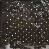 Warm white LED net lights illuminate a snowy outdoor scene with trees and potted plants.