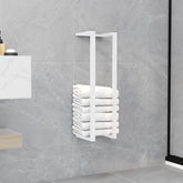 White steel towel rack mounted on bathroom wall, holding stacked white towels.