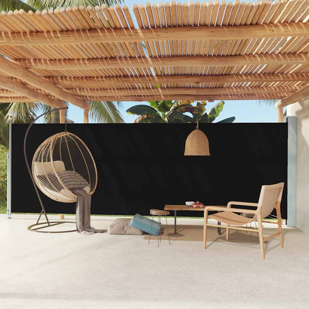 Black retractable side awning extended on a terrace with hanging egg chair and plants.