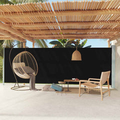 Black retractable side awning extended on a terrace with hanging egg chair and plants.